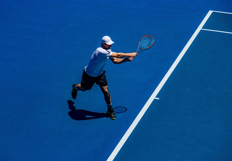 homme jouant au tennis sur le terrain